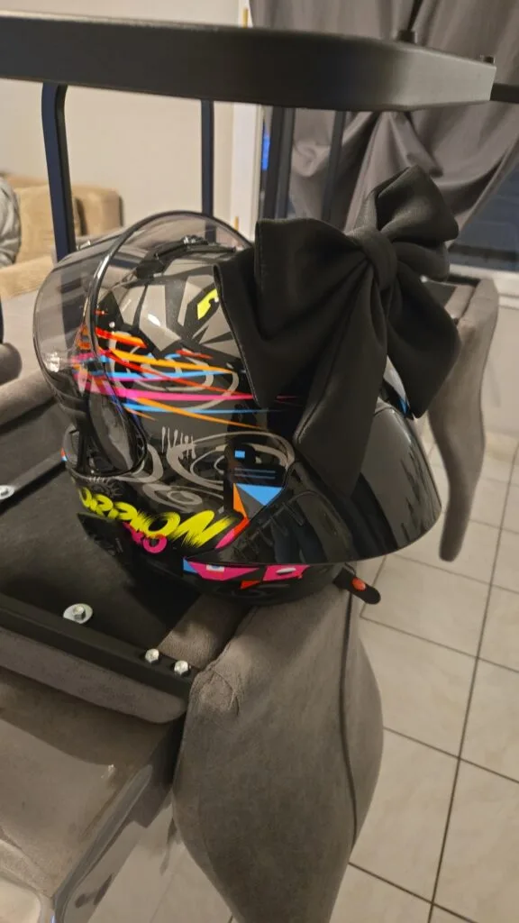 Photo de Laura : nœud noir fixé à l’arrière d’un casque moto décoré